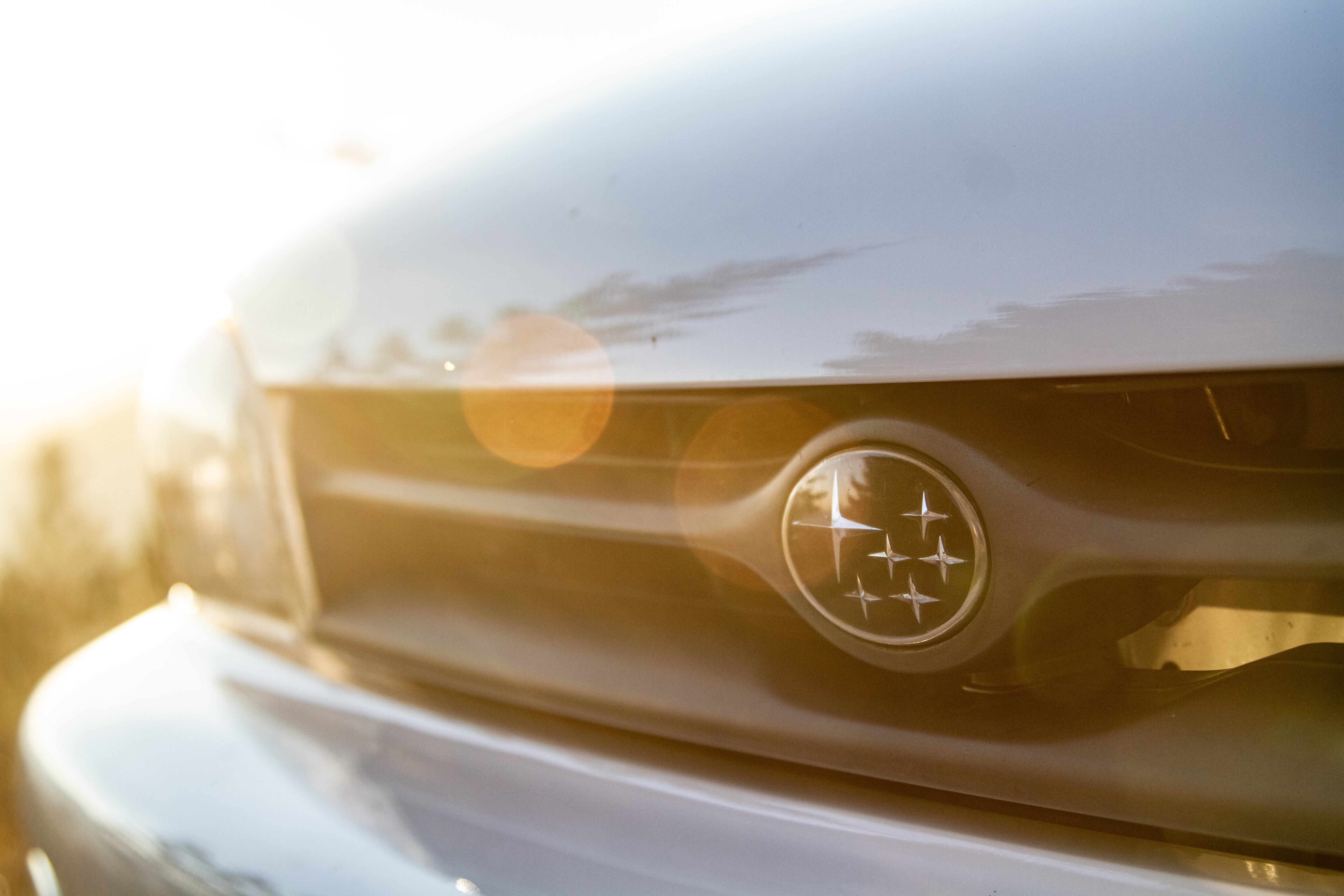 Car Logo in sun Subaru Impreza WRX STI on Slovenian highest mountain road Mangrt road